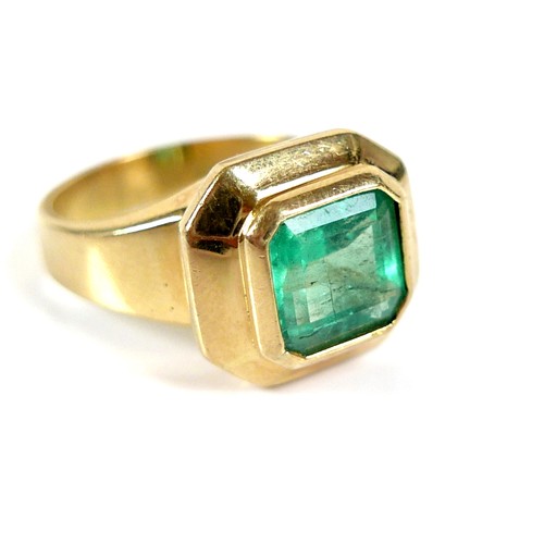 205 - An 18ct gold and Colombian emerald ring, the octagonal cut stone 8 by 8mm, within an octagonal setti... 