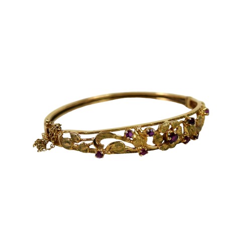 158 - A 9ct gold floral bangle, a yellow gold oval form hinged bangle, open work textured detail set with ... 