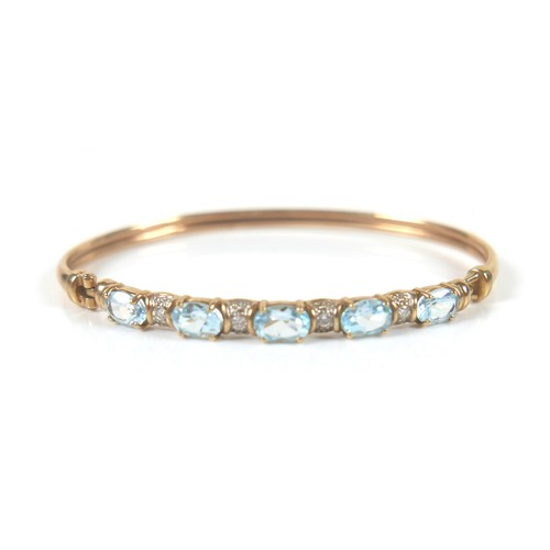 148 - Two gold and gem stone bangles, including a 9ct gold blue topaz bangle, the topaz interspersed with ... 