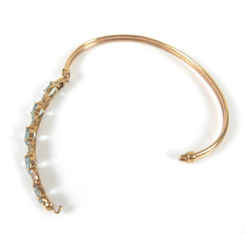 148 - Two gold and gem stone bangles, including a 9ct gold blue topaz bangle, the topaz interspersed with ... 