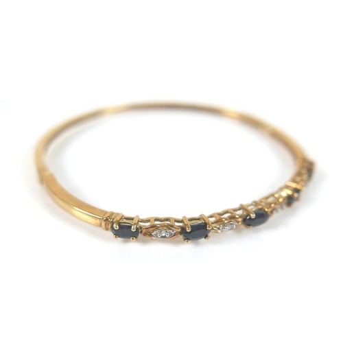 148 - Two gold and gem stone bangles, including a 9ct gold blue topaz bangle, the topaz interspersed with ... 