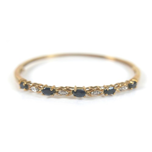 148 - Two gold and gem stone bangles, including a 9ct gold blue topaz bangle, the topaz interspersed with ... 