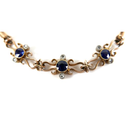 186 - A 9ct yellow gold and sapphire bracelet, with three scrolling panels, each set with a circular facet... 