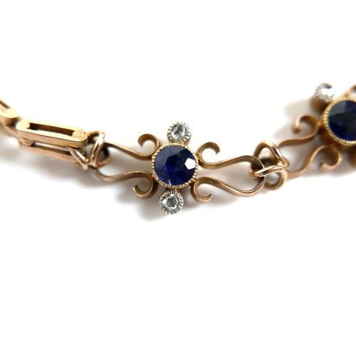 186 - A 9ct yellow gold and sapphire bracelet, with three scrolling panels, each set with a circular facet... 