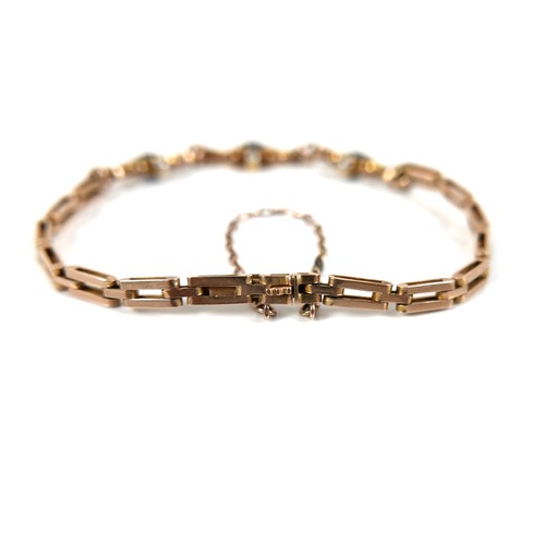 186 - A 9ct yellow gold and sapphire bracelet, with three scrolling panels, each set with a circular facet... 