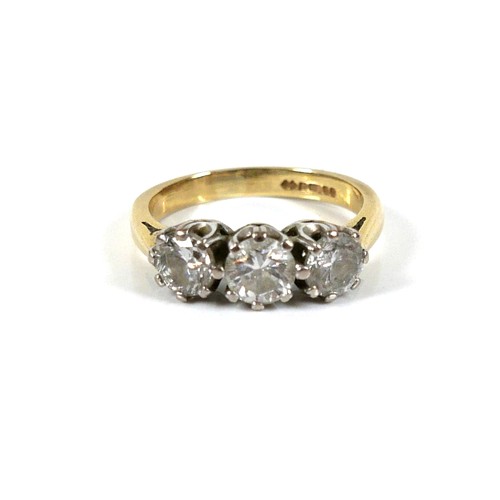 207 - An 18ct gold three stone diamond ring, round brilliant cut, central stone 0.6ct, 5.2 by 3.5, flanked... 