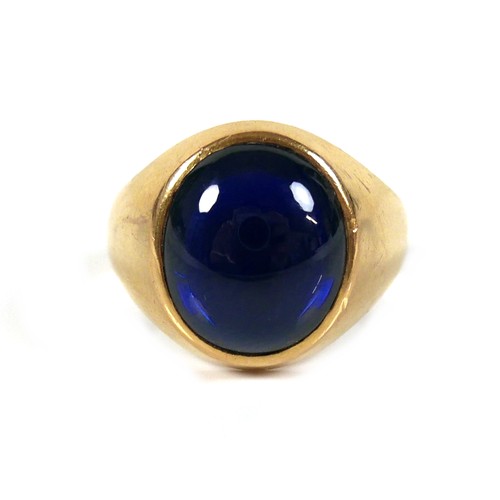 185 - An unmarked yellow gold ring, set with a cabochon blue stone, 13 by 12 by 5mm, on a plain graduating... 