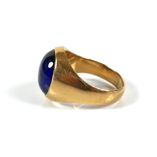 185 - An unmarked yellow gold ring, set with a cabochon blue stone, 13 by 12 by 5mm, on a plain graduating... 