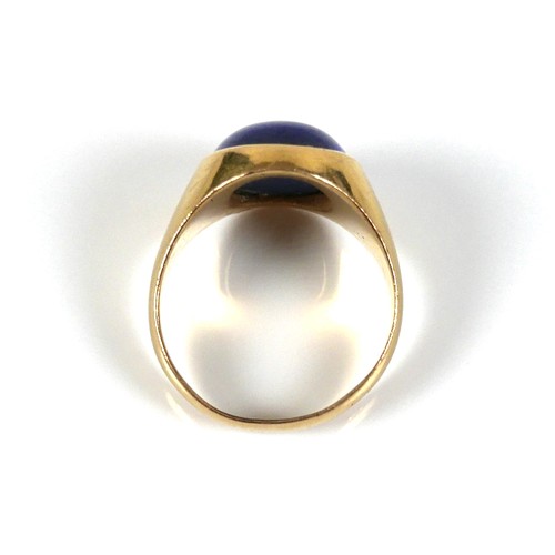 185 - An unmarked yellow gold ring, set with a cabochon blue stone, 13 by 12 by 5mm, on a plain graduating... 