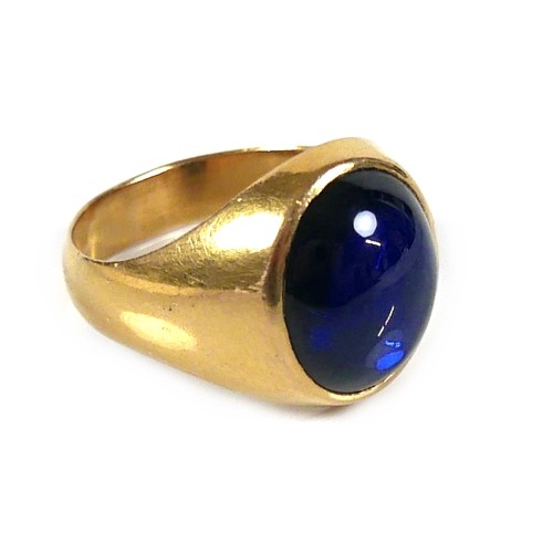 185 - An unmarked yellow gold ring, set with a cabochon blue stone, 13 by 12 by 5mm, on a plain graduating... 