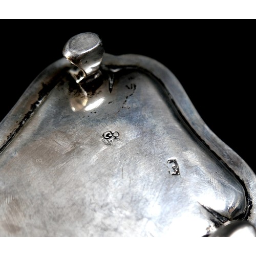 62 - A George III silver snuffer tray, with rubbed armorial engraving, scroll handle, raised upon four sc... 