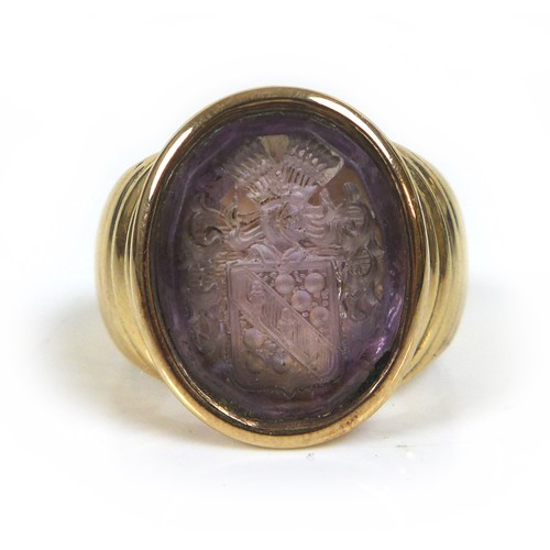 72 - An amethyst intaglio inset within a 9ct gold signet ring, unmarked but tests as 9ct, with armorial e... 