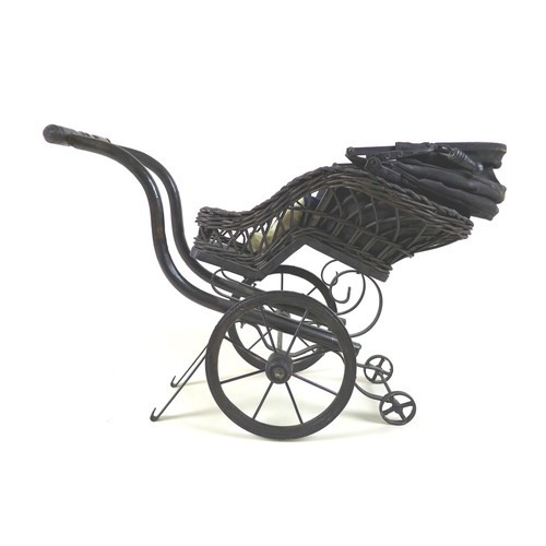 133 - A Victorian style doll's pram, woven wicker painted black, together with a modern bisque headed doll... 