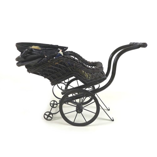 133 - A Victorian style doll's pram, woven wicker painted black, together with a modern bisque headed doll... 