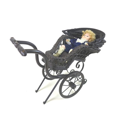 133 - A Victorian style doll's pram, woven wicker painted black, together with a modern bisque headed doll... 