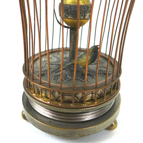 126 - A novelty wind-up clock in the form of a bird in a cage, early 20th century, central rotating orb wi... 