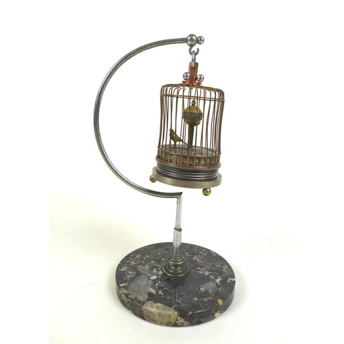 126 - A novelty wind-up clock in the form of a bird in a cage, early 20th century, central rotating orb wi... 