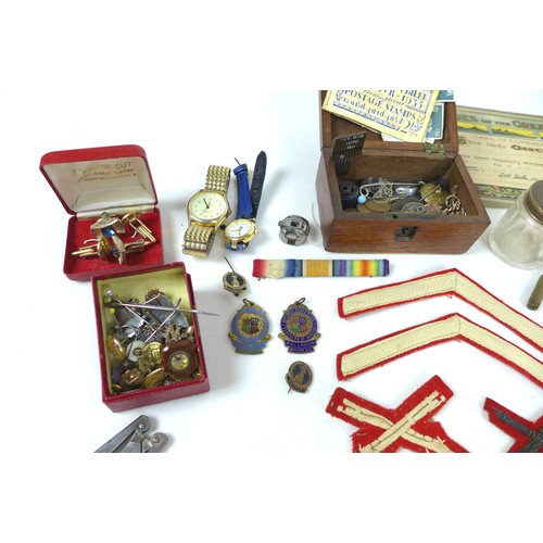 102 - A mixed group of collectables, including military memorabilia and badges, postcards, British coins a... 