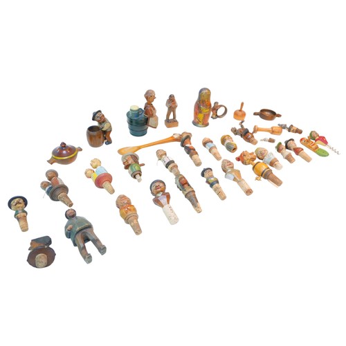 76 - A collection of continental wooden bottle stoppers and treen, including grotesque figures. (1 bag)