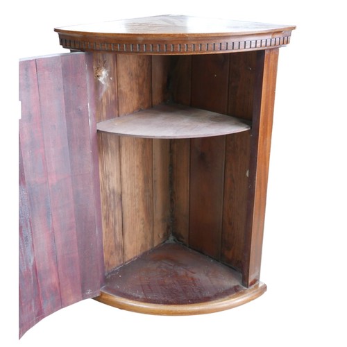 363A - A mahogany bow fronted corner cabinet, with single interior shelf.