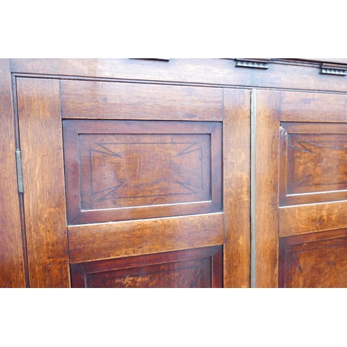 403 - A Georgian oak corner cupboard, in two sections, inlaid ebony detail to the frieze, with brass trim ... 