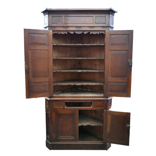 403 - A Georgian oak corner cupboard, in two sections, inlaid ebony detail to the frieze, with brass trim ... 