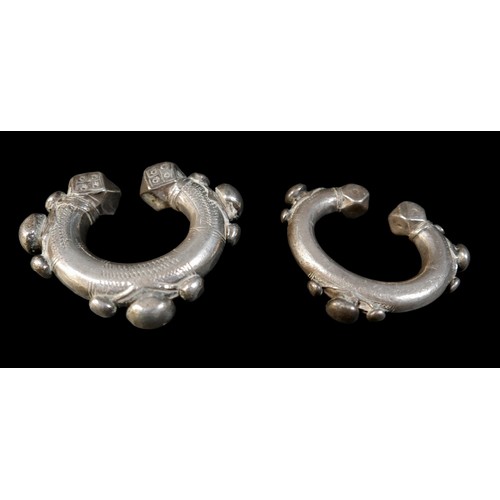 224 - Two Persian metal 'anklets', with stamped and applied decoration, larger anklet measured 9.5cm acros... 