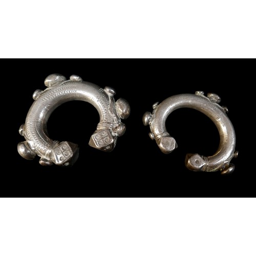 224 - Two Persian metal 'anklets', with stamped and applied decoration, larger anklet measured 9.5cm acros... 