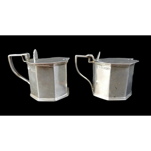 43 - Four pieces of Edwardian silver, comprising a pair of mustard pots with hinge lids, without glass li... 