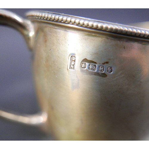 62 - A group of four silver items, comprising a milk jug, a sugar bowl, a tankard mustard with plated spo... 