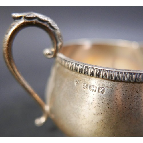 62 - A group of four silver items, comprising a milk jug, a sugar bowl, a tankard mustard with plated spo... 