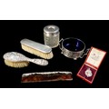 A collection of Edwardian and later silver, including a twin handled sugar bowl with blue glass line... 