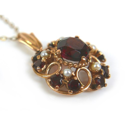 247 - A 9ct yellow gold pendant necklace, the circular pendant set centrally with a garnet, 8mm, surrounde... 