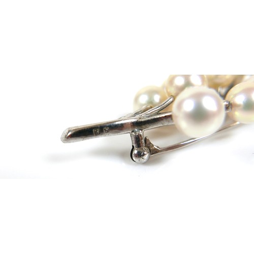 230 - Two Mikimoto pearl and white metal brooches, 65 and 50mm high. (2)