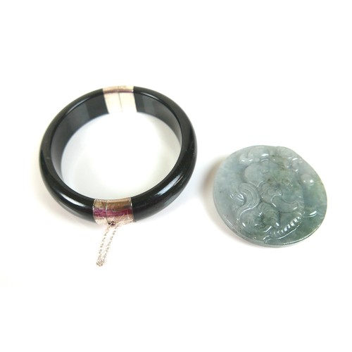 144 - Two pieces of jade jewellery, comprising a black jadeite and silver hinged bangle, with certificate ... 