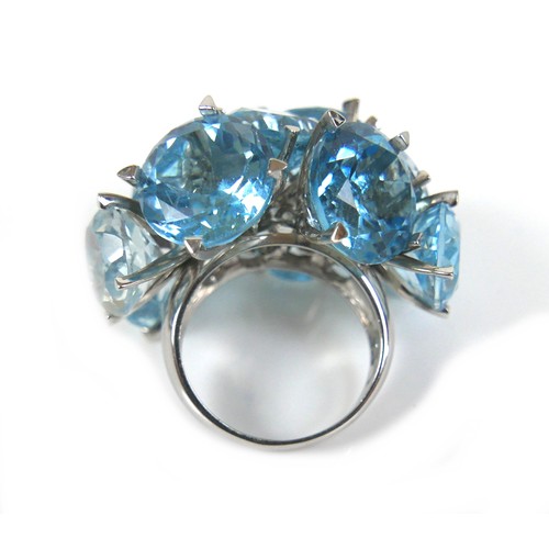 298 - An unusual 18ct white gold dress ring, fitted with twelve brilliant cut blue stones, possibly topaz ... 