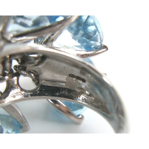 298 - An unusual 18ct white gold dress ring, fitted with twelve brilliant cut blue stones, possibly topaz ... 