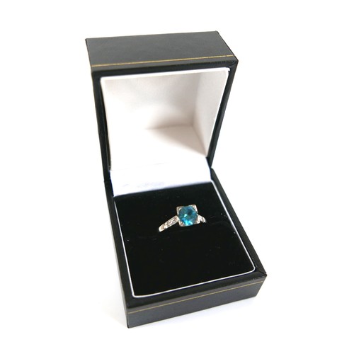 228 - An 18ct white gold and platinum, blue topaz and diamond ring, head size 7 by 7mm, set with diamond s... 