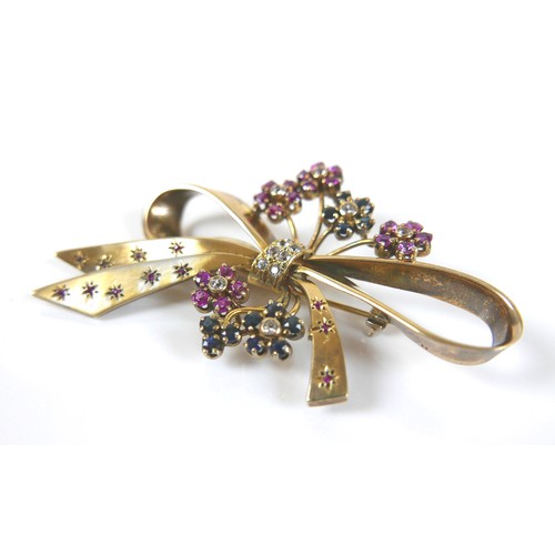 181 - A vintage gilt metal designer bow shaped brooch, set with blue, pink and white sapphires, 75 by 48mm... 