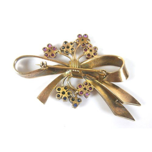 181 - A vintage gilt metal designer bow shaped brooch, set with blue, pink and white sapphires, 75 by 48mm... 