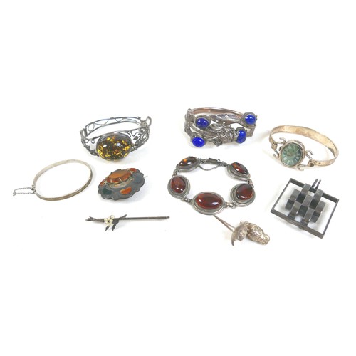 149 - A group of silver jewellery, comprising a Chinese silver hinged bangle set with lapis lazuli and for... 