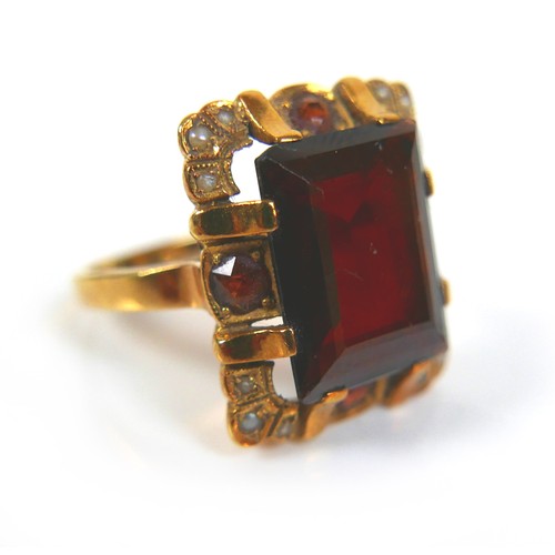 200 - An 18ct yellow gold dress ring, set with an emerald cut red stone, possibly garnet, 14.3 by 11.2 by ... 