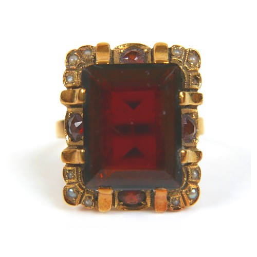 200 - An 18ct yellow gold dress ring, set with an emerald cut red stone, possibly garnet, 14.3 by 11.2 by ... 