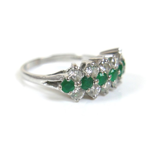 271 - An 18ct white gold diamond and emerald cluster ring, with a single row of eight round cut emeralds, ... 