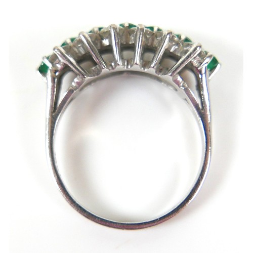 271 - An 18ct white gold diamond and emerald cluster ring, with a single row of eight round cut emeralds, ... 