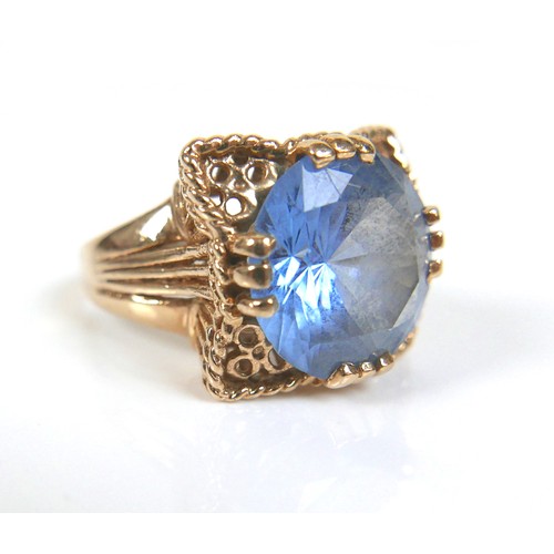 203 - Two gold dress rings, comprising a 9ct yellow gold ring set with a blue round cut stone, 14mm, size ... 