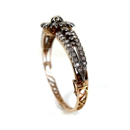 302 - A French early 20th century 18ct yellow gold and white metal diamond hinged bangle, the central flow... 