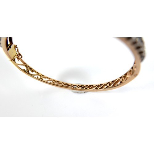 302 - A French early 20th century 18ct yellow gold and white metal diamond hinged bangle, the central flow... 