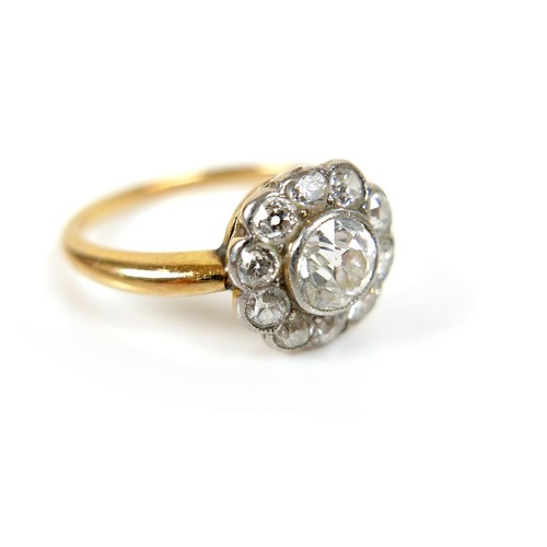 279A - An 18ct gold diamond daisy set ring, central stone approximately 5mm in diameter, surrounded by ten ... 