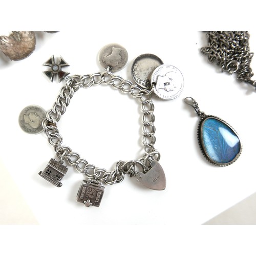 151A - A group of silver jewellery, comprising a charm bracelet, with 19th century coins, miniature bible, ... 